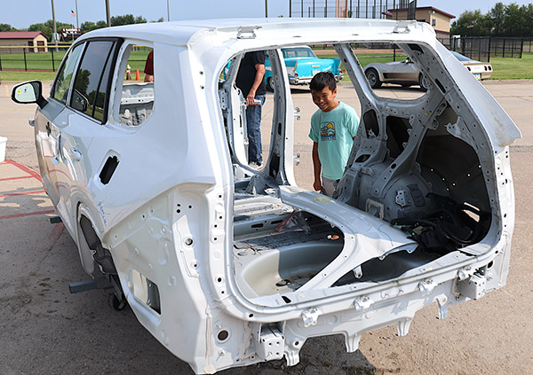 Smiling child looking at car body