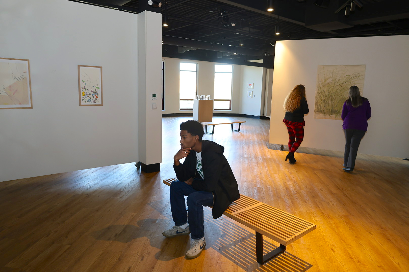 Student sitting and viewing art in art gallery