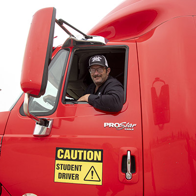 Man smiling out of window of semi truck