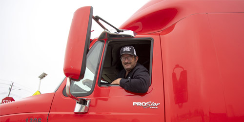Man smiling out of window of semi