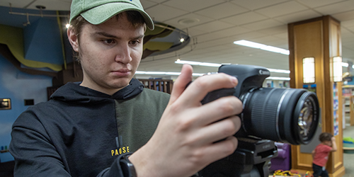 communication student with a camera