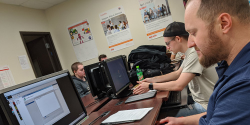 male student coding for a networking class