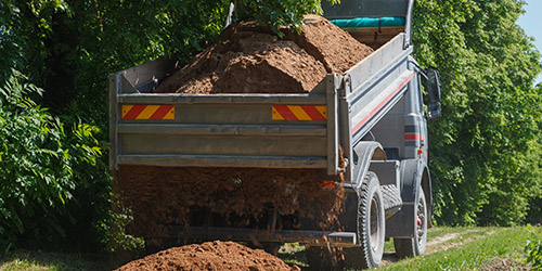dump truck dropping dirt on ground