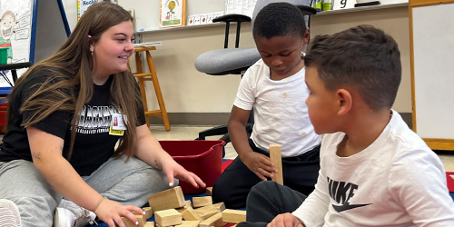 Student playing with preschoolers