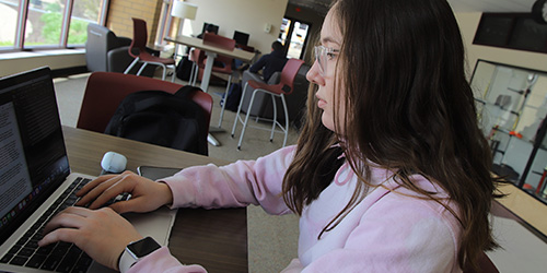 female student working on her laptop