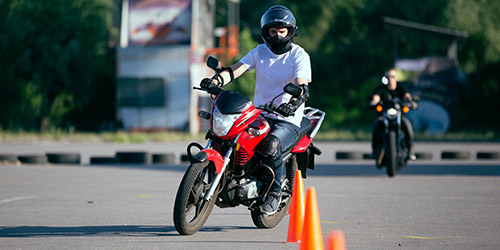 Man riding motorcycle through orange cones