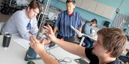 male students doing a physics experiment