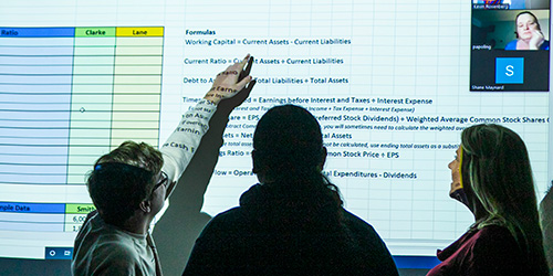 students looking at a spreadsheet on big screen