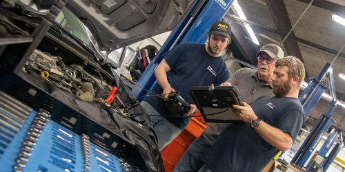 Two students and instructor testing an engine