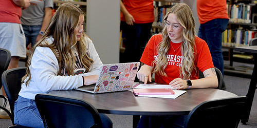 Students sitting at a table with a laptop