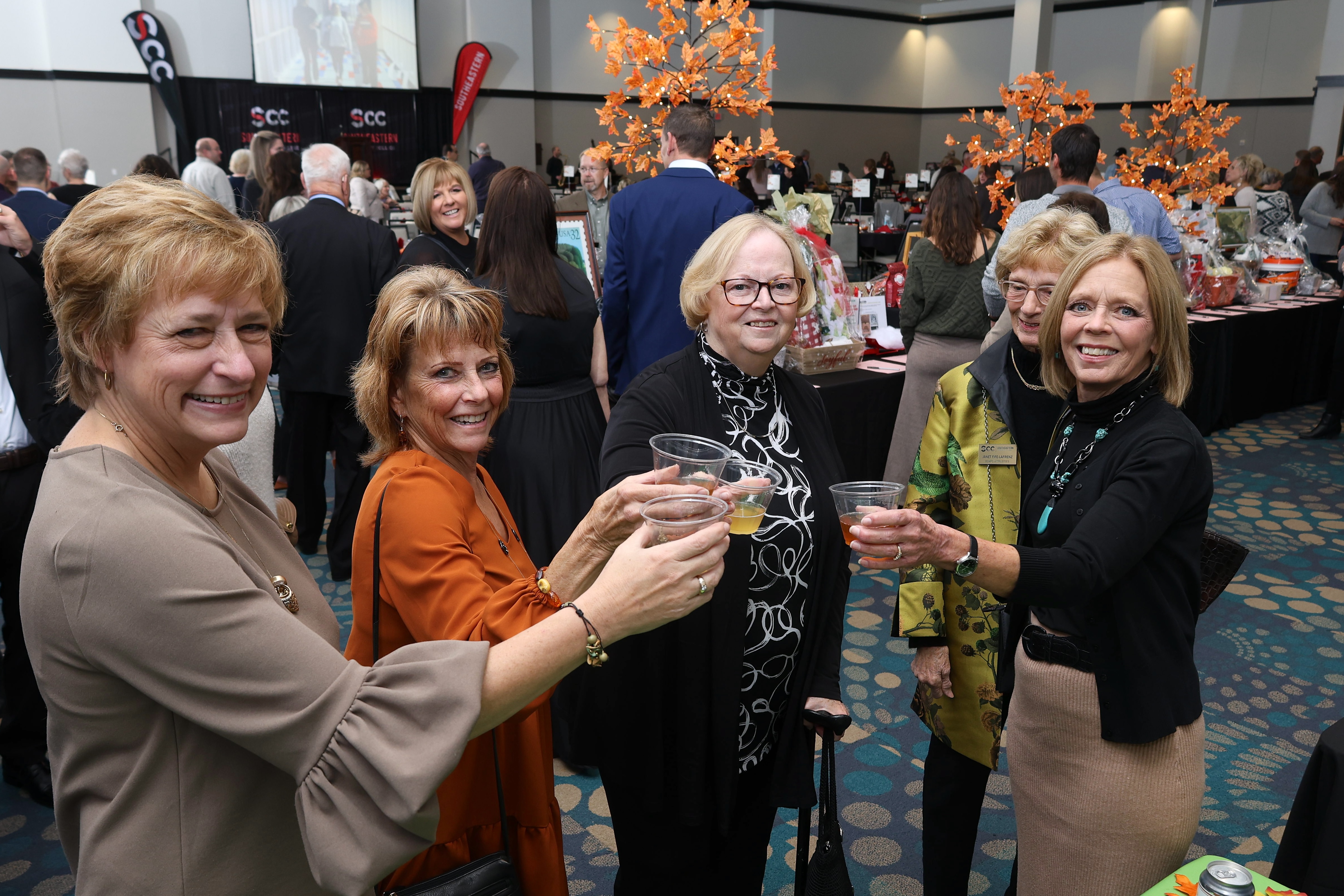 Women smiling and raising glasses of wine