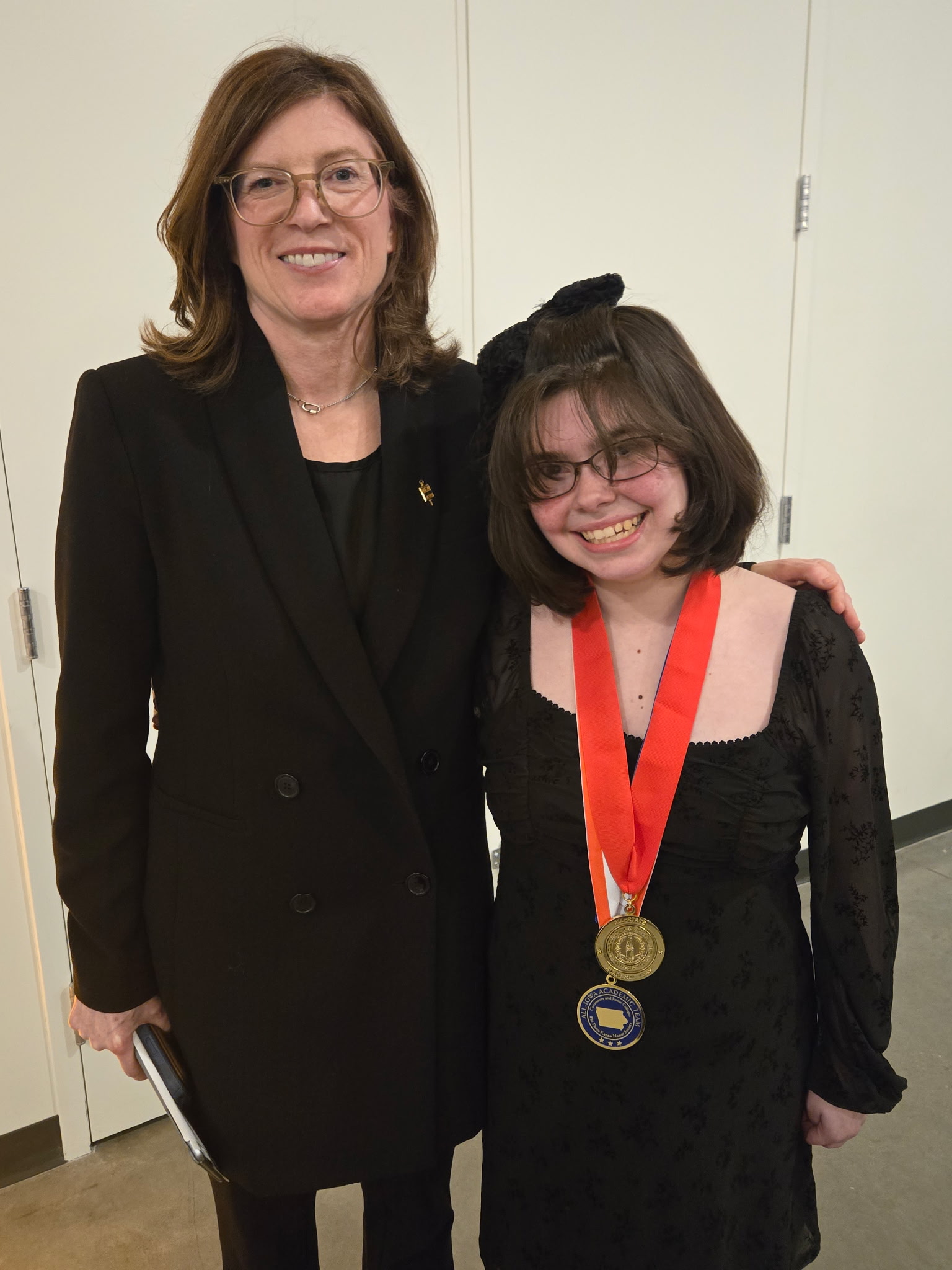 Student with award ribbon smiling with adult