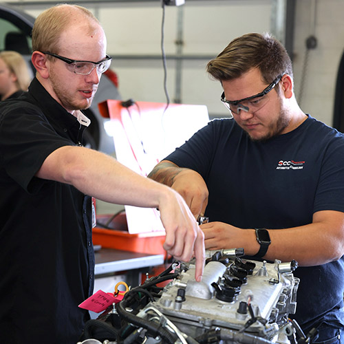Auto tech students and instructor working on engine