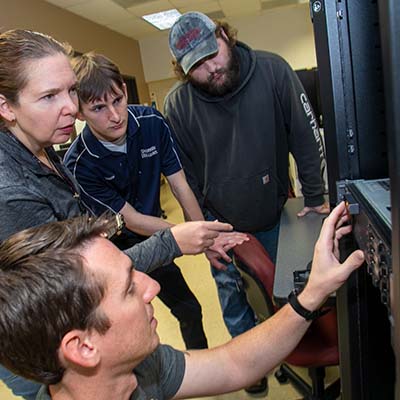 Computer students working on a server rack