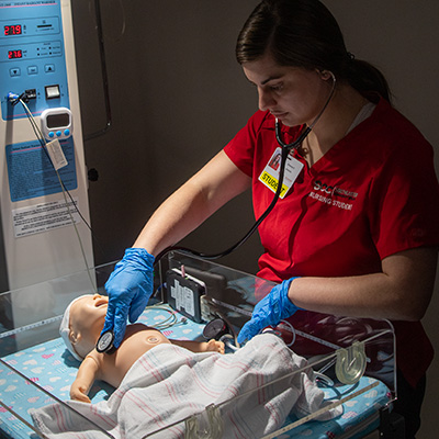 nursing student caring for a simulation baby.