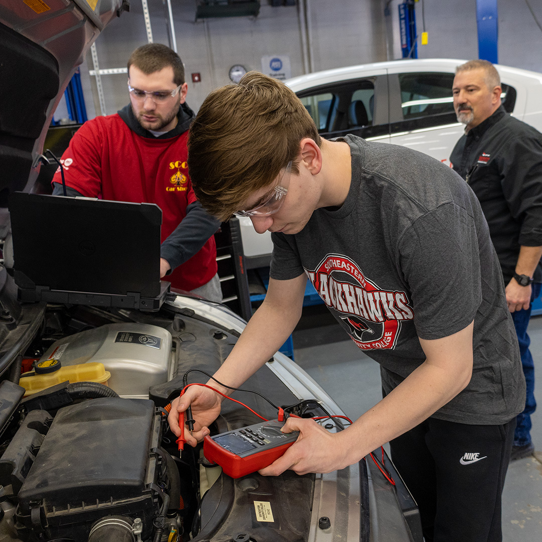 Auto tech students performing diagnostics on a Toyota Prius