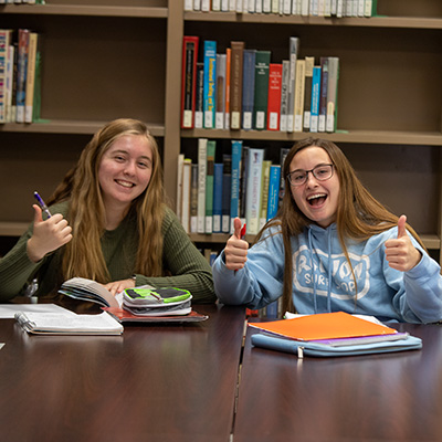 two students taking a break from studying in the library